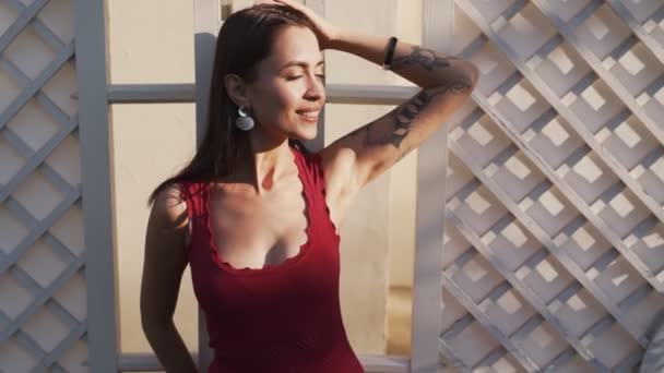 Портрет молодой женщины с красивой улыбкой, позирующей в лучах солнца, замедленной съемки — стоковое видео