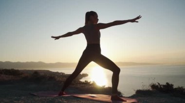 Sabahın erken saatlerinde güneş ışınlarında esneme yapan kadının silueti, yavaş hareket