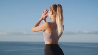 Sabah kadın uygulamaları yoga backside görünümü, arka planda deniz, yavaş hareket