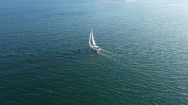 Güneşli bir günde deniz suyunda beyaz yelkenli yat havadan görüntüleri, geniş açı görünümü