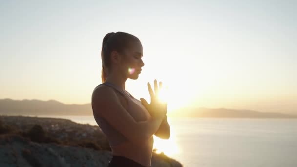 Silueta dívky medituje a soustřeďuje se na dýchání, východ slunce, pomalý pohyb — Stock video
