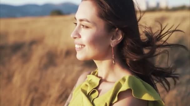 Retrato de mujer sonriente en dorado rayo de sol, viento sopla su pelo, cámara lenta — Vídeos de Stock