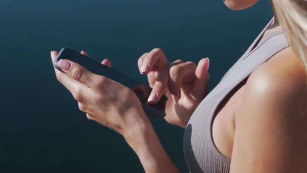 Κοντινό επάνω γυναίκα χέρια τύπους κείμενο μήνυμα στο κινητό τηλέφωνο, θάλασσα στο παρασκήνιο — Αρχείο Βίντεο