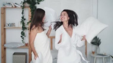 Yatak odasına atlayan iki kız ve evde yastıklarla dans eden, komik bir video.
