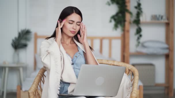 Портрет втомленої жінки працює на ноутбуці вдома і має жахливий головний біль — стокове відео