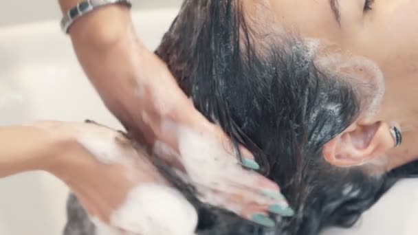 Zblízka ruka kadeřnice myje vlasy šamponem na ženu, zpomalený pohyb — Stock video