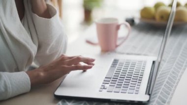 Kapalı kadın elleri laptopta dokunmatik ped kullanıyor, kız evde bilgisayarla çalışıyor.