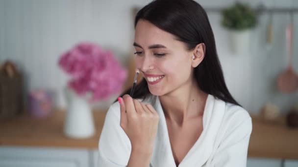 Portrait of beautiful woman makes makeup and use brush to put powder on her face — Stock Video