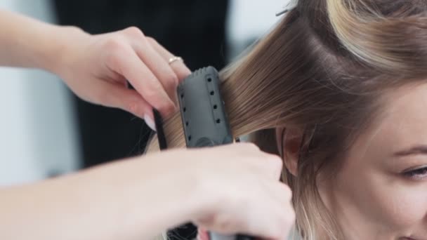 Close up cabeleireiro penteia fios de cabelo do cliente no salão de beleza, câmera lenta — Vídeo de Stock