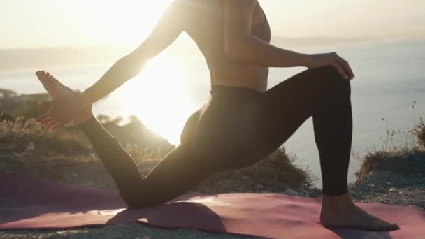 Silhuett del av kvinnlig kropp gör yoga motion, stretching i solstråle, slow motion — Stockvideo