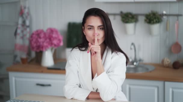 Mujer joven muestra gesto más tranquilo, pone el dedo en los labios, pide silencio — Vídeos de Stock