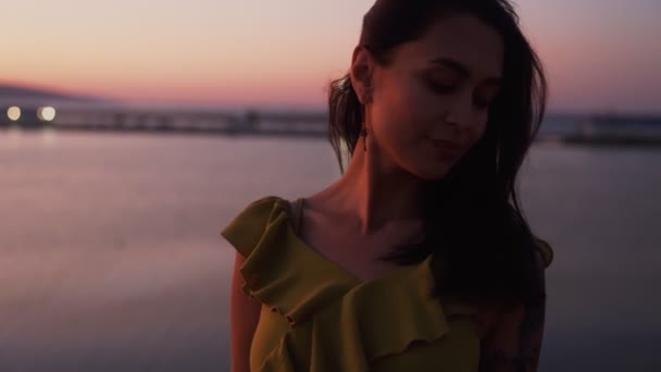 Retrato de mulher sorridente ao pôr do sol, mar no fundo vento sopra seu cabelo — Vídeo de Stock