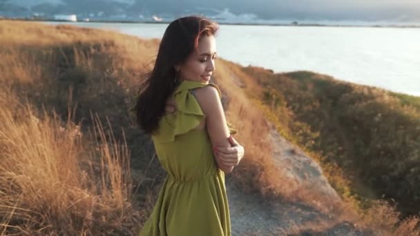 Porträtt av leende kvinna i guld stråle av sol, blåser vinden hennes hår, slow motion — Stockvideo