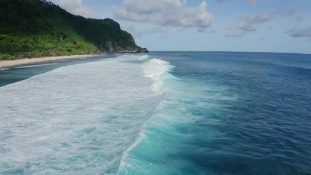 Vista aérea del océano con hermosas olas onduladas espumosas, montaña en el fondo — Vídeos de Stock