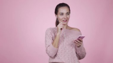 Pembe arka planda izole edilmiş cep telefonu kullanan bir kadın görüntülü konuşma yapıyor