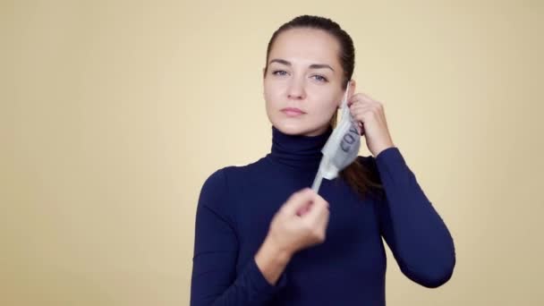 Vrouw neemt beschermende medische masker covid-19 af, ademt diep en glimlacht — Stockvideo