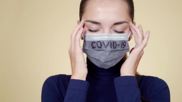 Женщина в медицинской маске страдает от головной боли и кашля, ковид-19 — стоковое видео