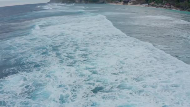 Aerial top view powerful waves on blue turquoise ocean crashing and foaming. — Stock Video