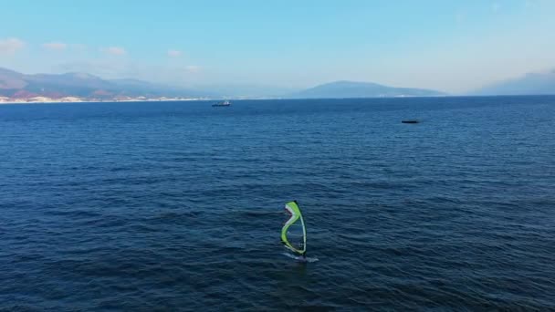 Vista aérea del windsurfista surfeando en calma azul profundo del mar, deporte extremo — Vídeo de stock