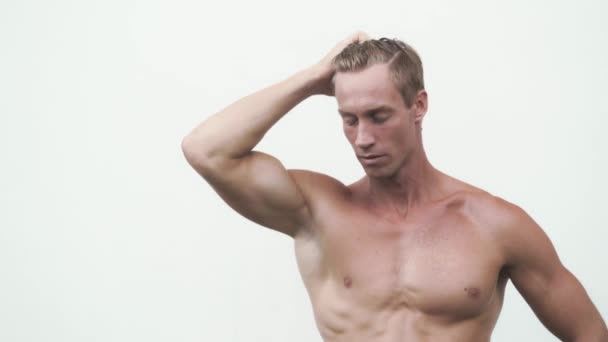 Uomo senza maglietta mostra muscoloso pompato bicipiti sul braccio, sfondo bianco — Video Stock