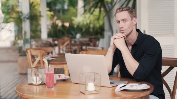 Επιχειρηματίας κάθεται στο τραπέζι χρησιμοποιώντας συσκευές υπολογιστή για εργασία σε κομψό καφέ — Αρχείο Βίντεο