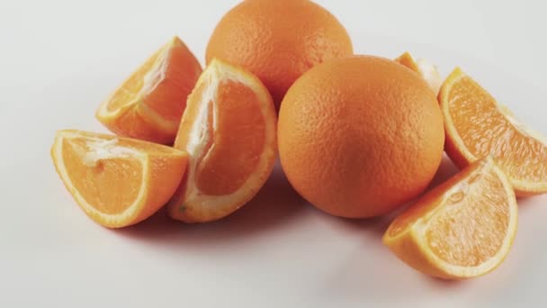 Primer plano, rodajas de naranja sobre mesa giratoria aisladas sobre fondo blanco — Vídeos de Stock