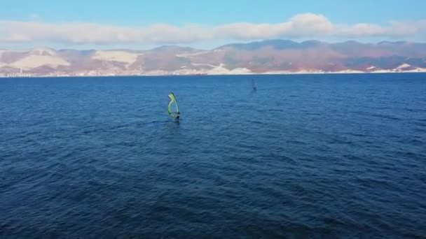 Vista aérea del windsurfista surfeando en calma azul profundo del mar, deporte extremo — Vídeos de Stock
