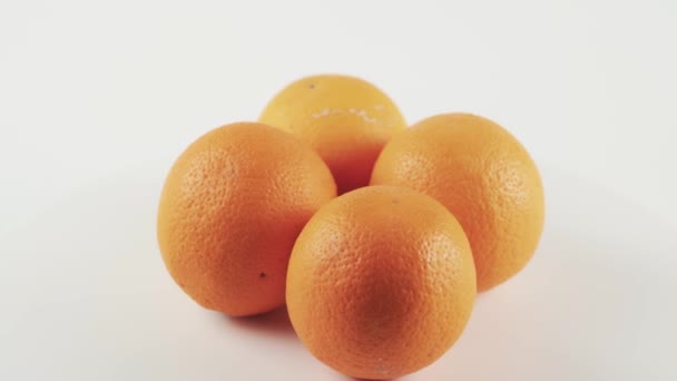Blisko, cztery pomarańcze na obrotowym stole izolowane na białym tle — Wideo stockowe