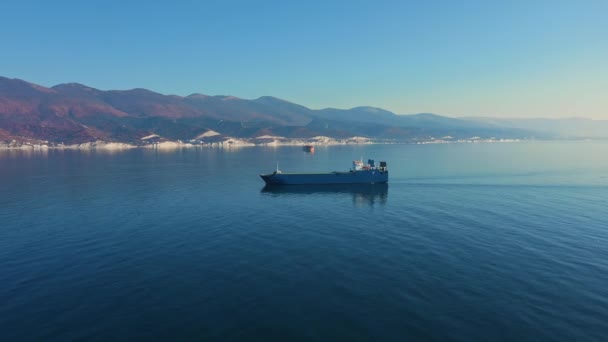 Vista aérea del buque de carga ultra grande en el mar sale del puerto en el día soleado — Vídeos de Stock