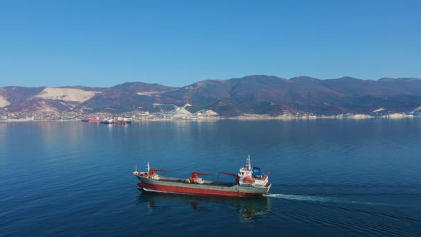 Luchtzicht na het ultragrote vrachtschip op zee verlaat de haven op zonnige dag — Stockvideo
