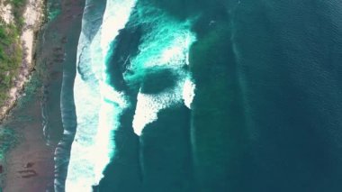 Sakin ve güzel okyanus dalgaları sahilde yuvarlanır ve köpük oluşturur.