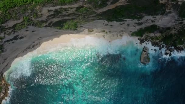 Top down luchtfoto van azuurblauw water, golven van de oceaan crashen op wild strand — Stockvideo