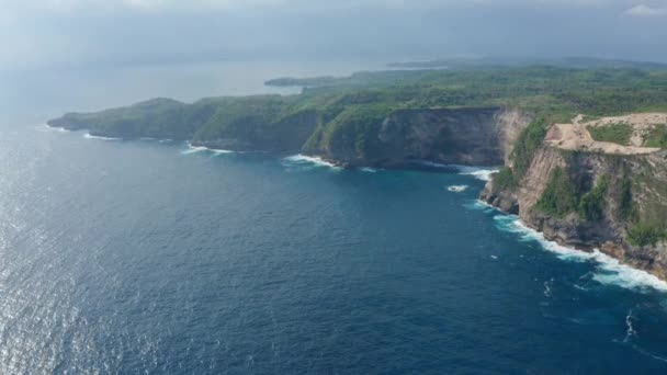 Vista aerea della spiaggia di Kelingking nell'isola di Nusa Penida, oceano azzurro, montagne — Video Stock