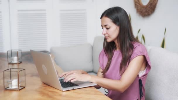 Porträt einer schönen Frau, die im Café sitzt und Laptop für die Arbeit benutzt — Stockvideo