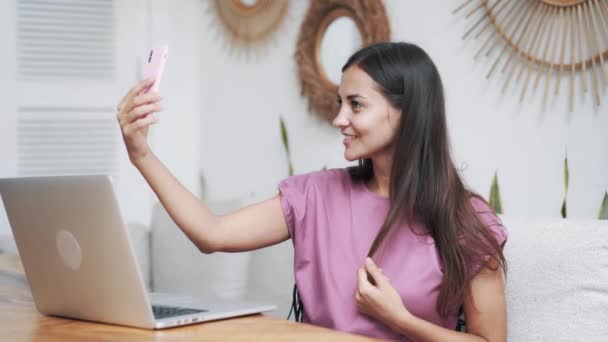 Mujer blogger posa y toma historia en elegante cafetería, se toma selfie en el teléfono — Vídeo de stock