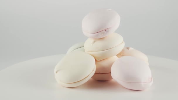 Close-up of coloured marshmallows it plate rotation over white background. — Stock Video