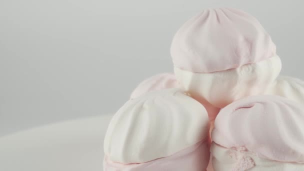 Detailní záběr barevných marshmallows to deska otáčení na bílém pozadí. — Stock video