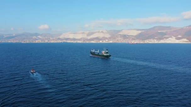Denizdeki ultra büyük kargo gemisinin hava görüntüsü güneşli bir günde limandan ayrılıyor. — Stok video