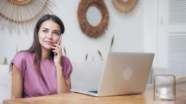 Retrato de mujer de negocios en la cafetería utiliza el ordenador portátil para el trabajo y hablar por teléfono — Vídeos de Stock