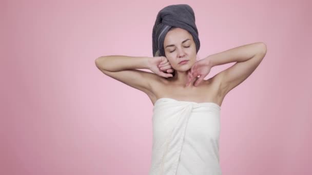 女性の頭の上にタオルを手を伸ばし、あくび、十分な睡眠を得ることができませんでしたピンクの背景に隔離 — ストック動画