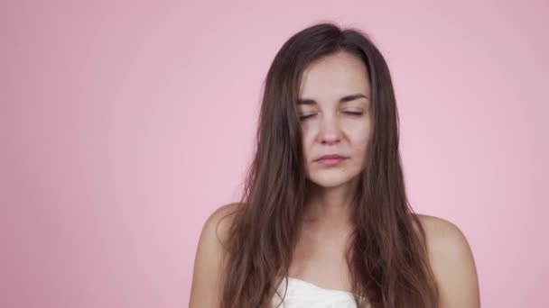 Женщина просыпается рано, не выспалась, изолирована на розовом фоне — стоковое видео