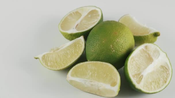 Close up, pieces of lime on white rotating table, concept of citrus — Stock Video