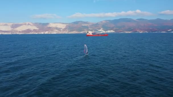 Вид с воздуха на виндсерфинг в спокойном глубоководье моря, экстремальный спорт — стоковое видео