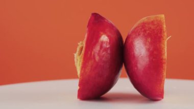 Turuncu arkaplanda izole edilmiş nektarin parçalarını döndürme tablosunda kapat