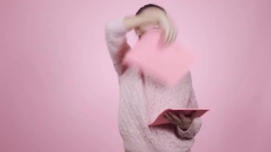 Mutlu, genç, beyaz kadın her yere pembe çarşaf fırlatıyor. 