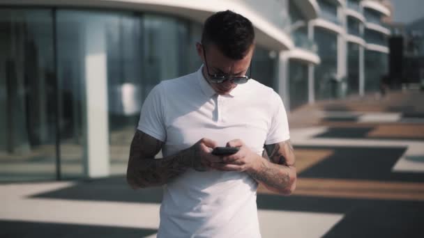 백인젊은 힙합 가수가 스마트폰으로 소셜 네트워크에서 메시지를 입력하고 있습니다. — 비디오