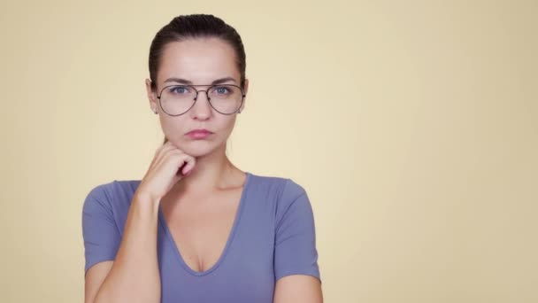 Молодая красивая нерешительная белая женщина в очках и позирует — стоковое видео