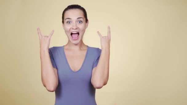 Woman shows rock with her fingers rejoicing in the upcoming musical event — Stock Video