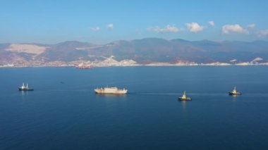 Kargo ve servis gemilerinin hava görüntüsü kayalık kıyılardan geçiyor.