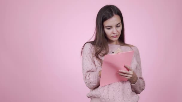 Zamyślony piękny kaukaski młody kobieta pisze a zakupy lista — Wideo stockowe